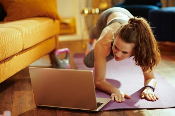 Woman using RhinoFit software on laptop to exercise at home