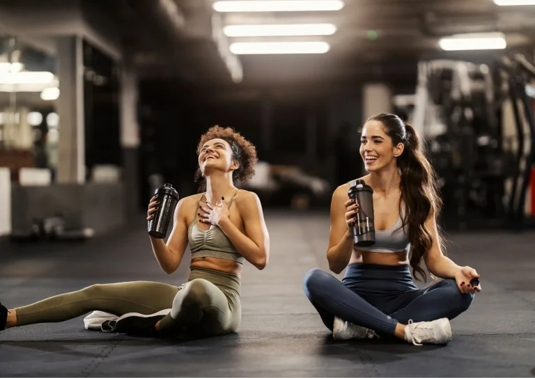 Image of two women in gym drinking sports nutrition